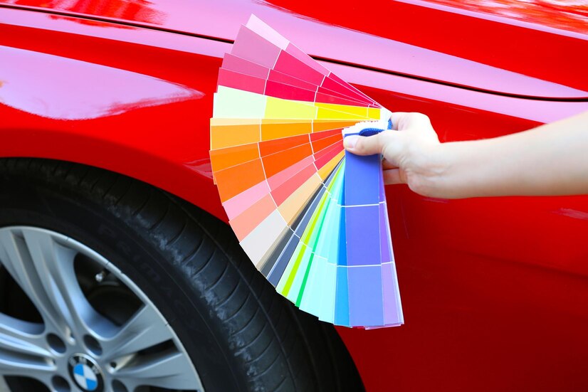 female-hand-with-color-samples-red-car-background_392895-570699